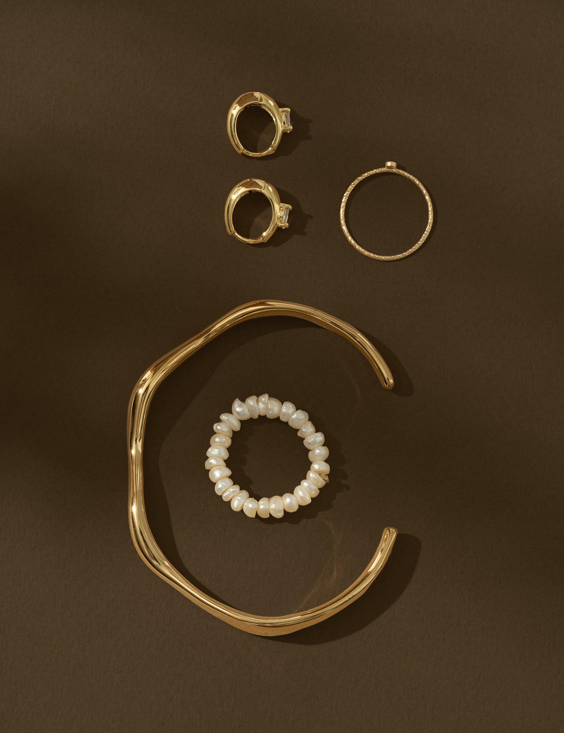 gold jewelry on brown background
