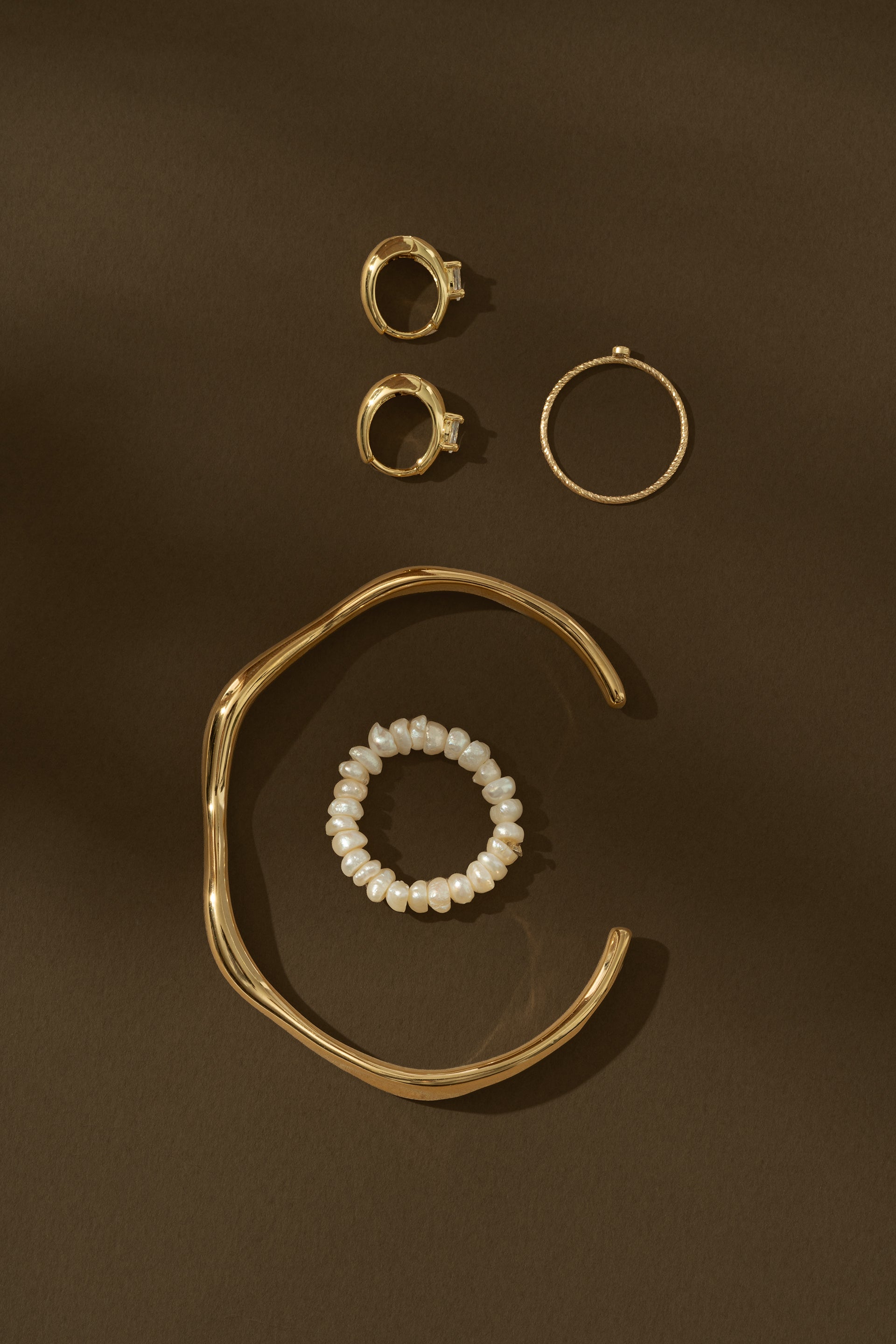 gold jewelry on brown background
