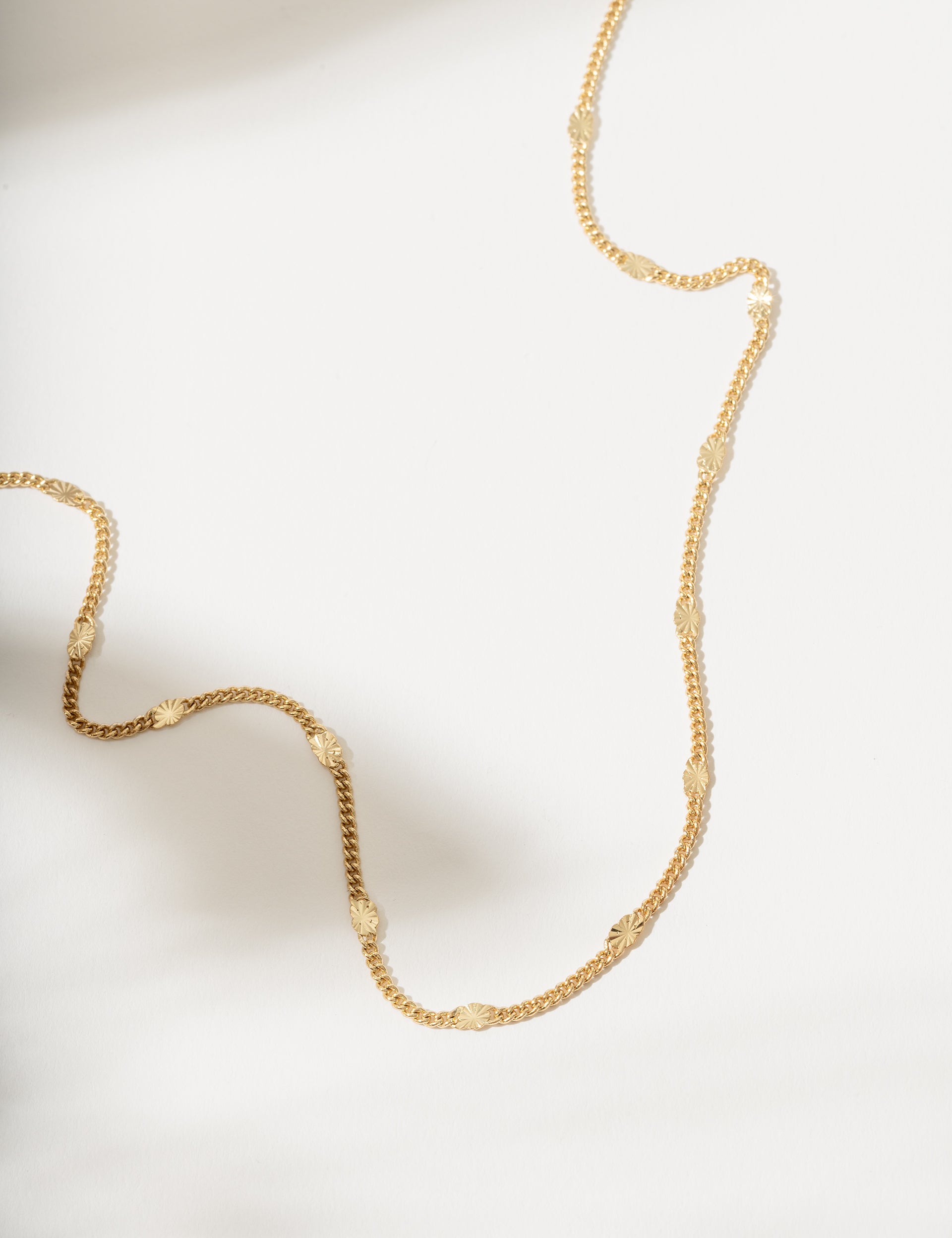 Gold necklace on a light background