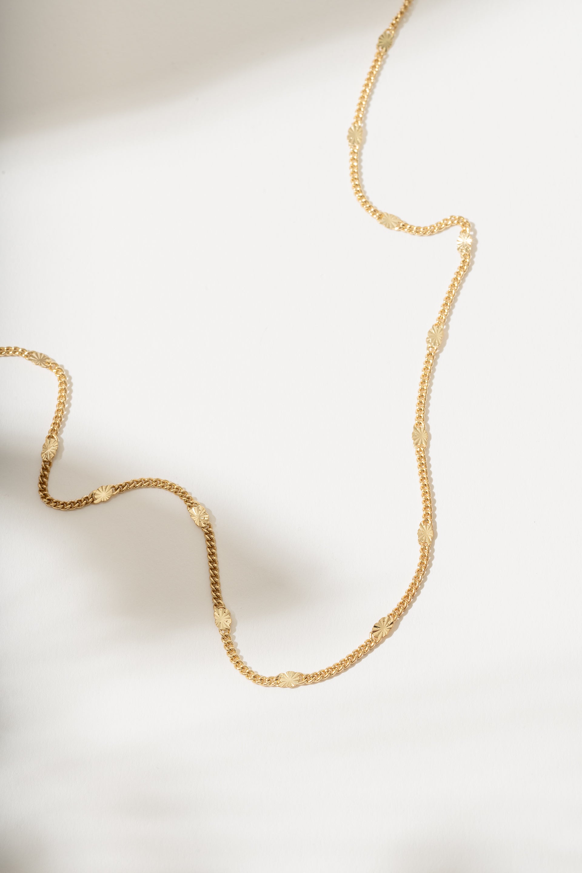 Gold necklace on a light background