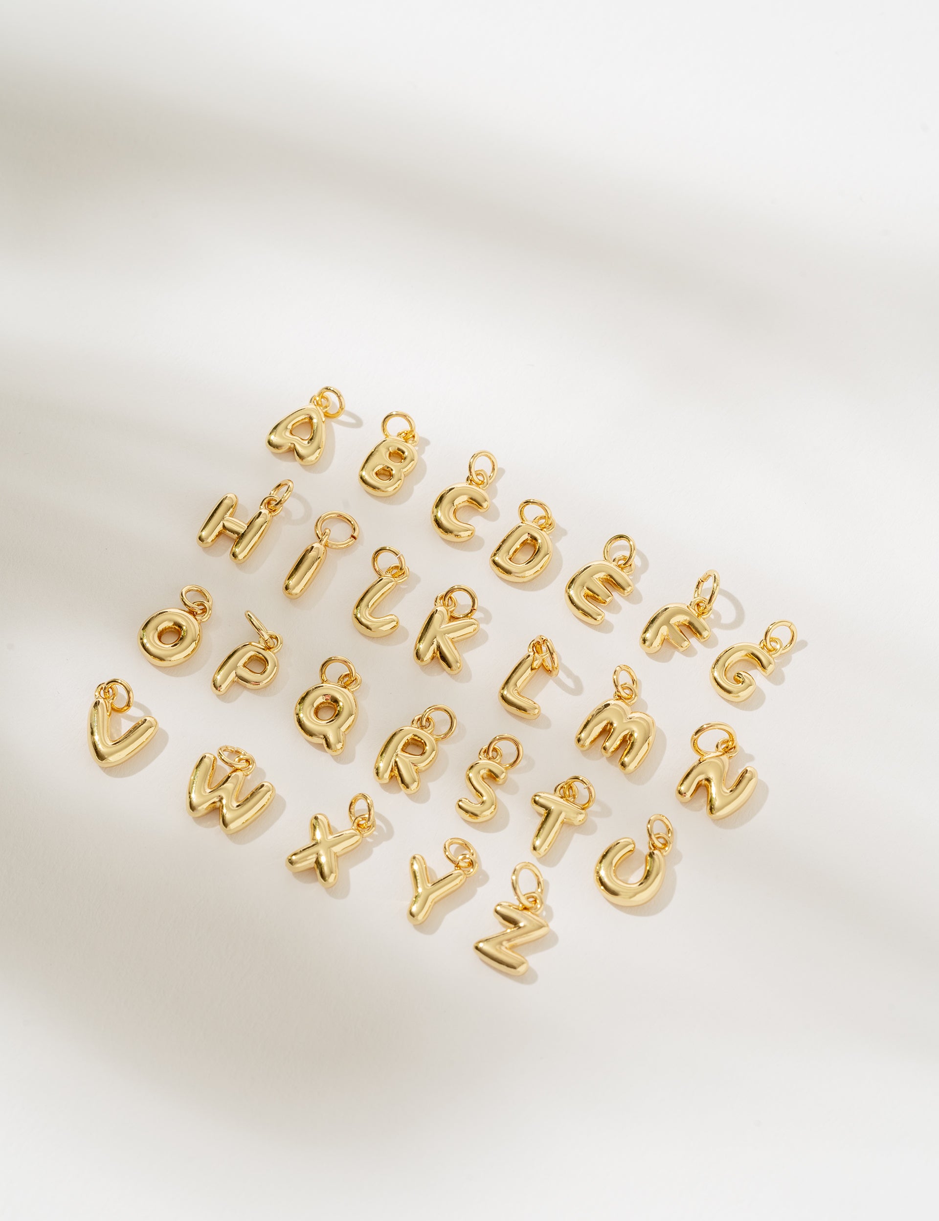 Gold letter charms on a white background