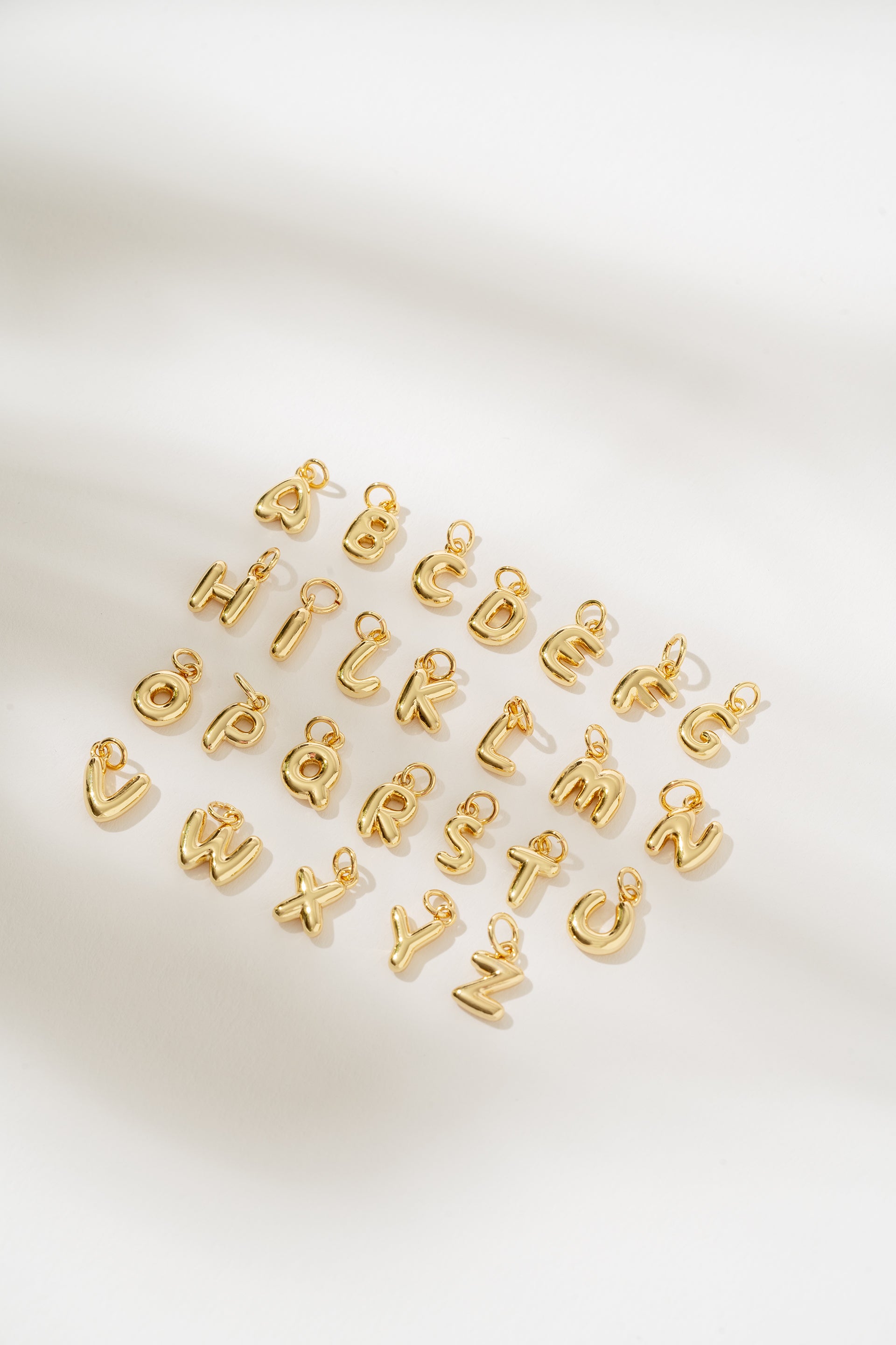 Gold letter charms on a white background