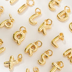 Gold letter charms on a white background