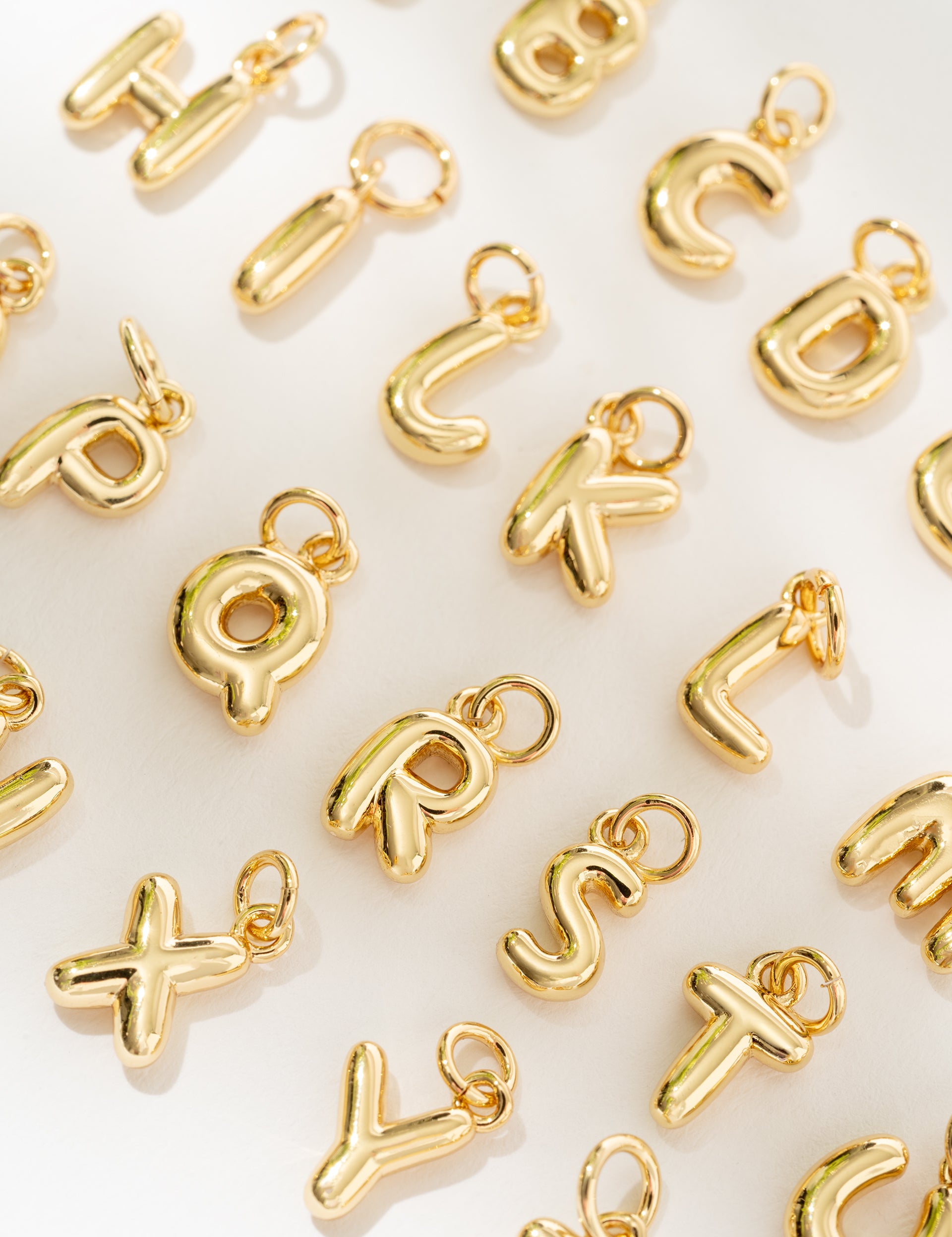 Gold letter charms on a white background