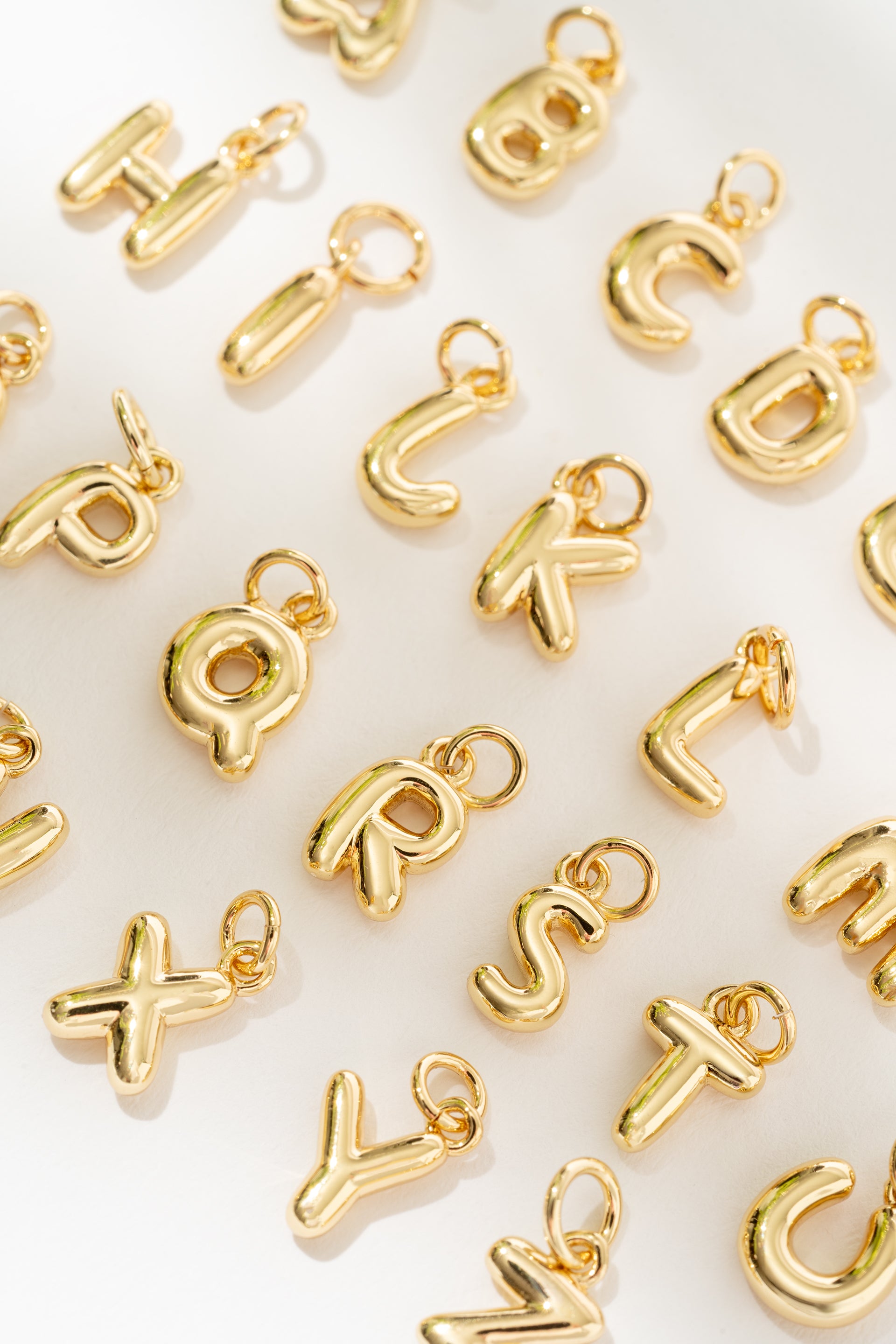 Gold letter charms on a white background