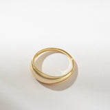 Gold dome ring on a light gray background