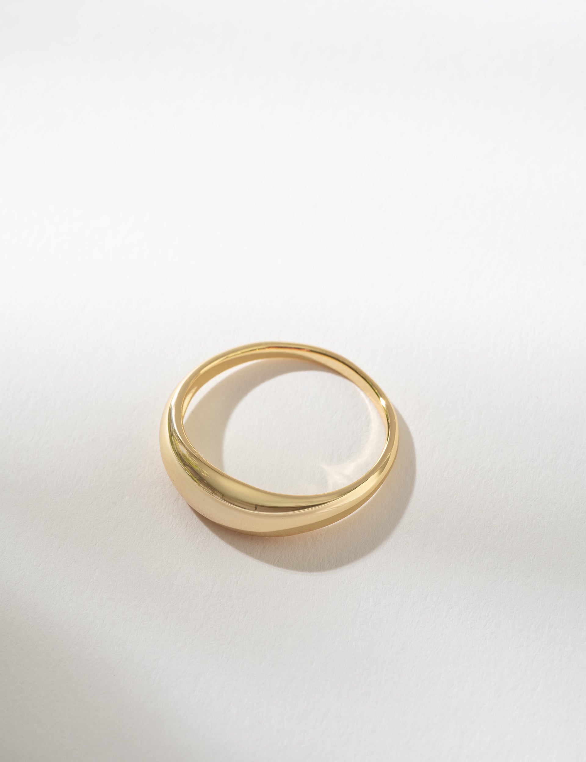 Gold dome ring on a light gray background