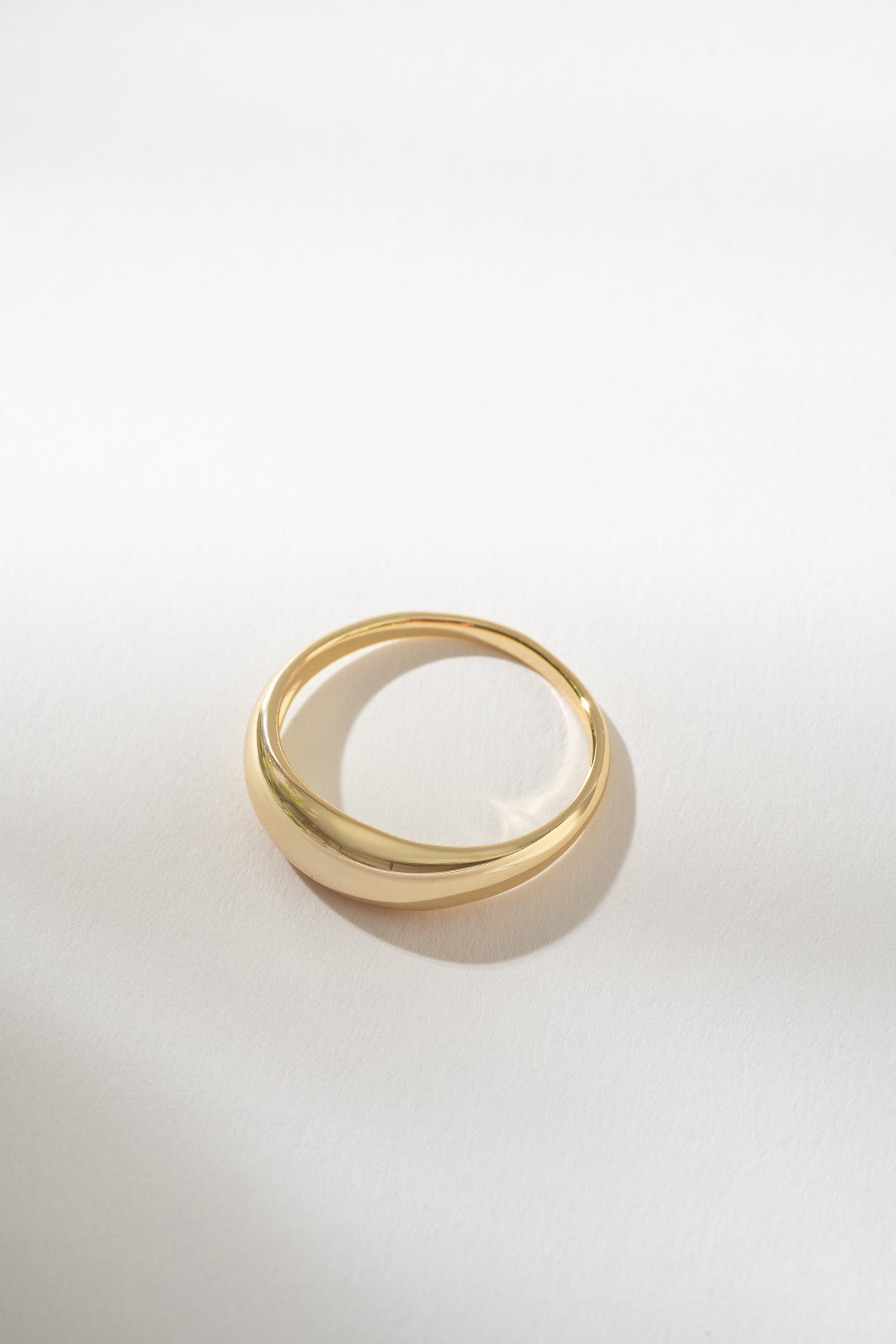 Gold dome ring on a light gray background
