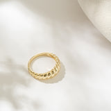 Gold ring on a light beige background