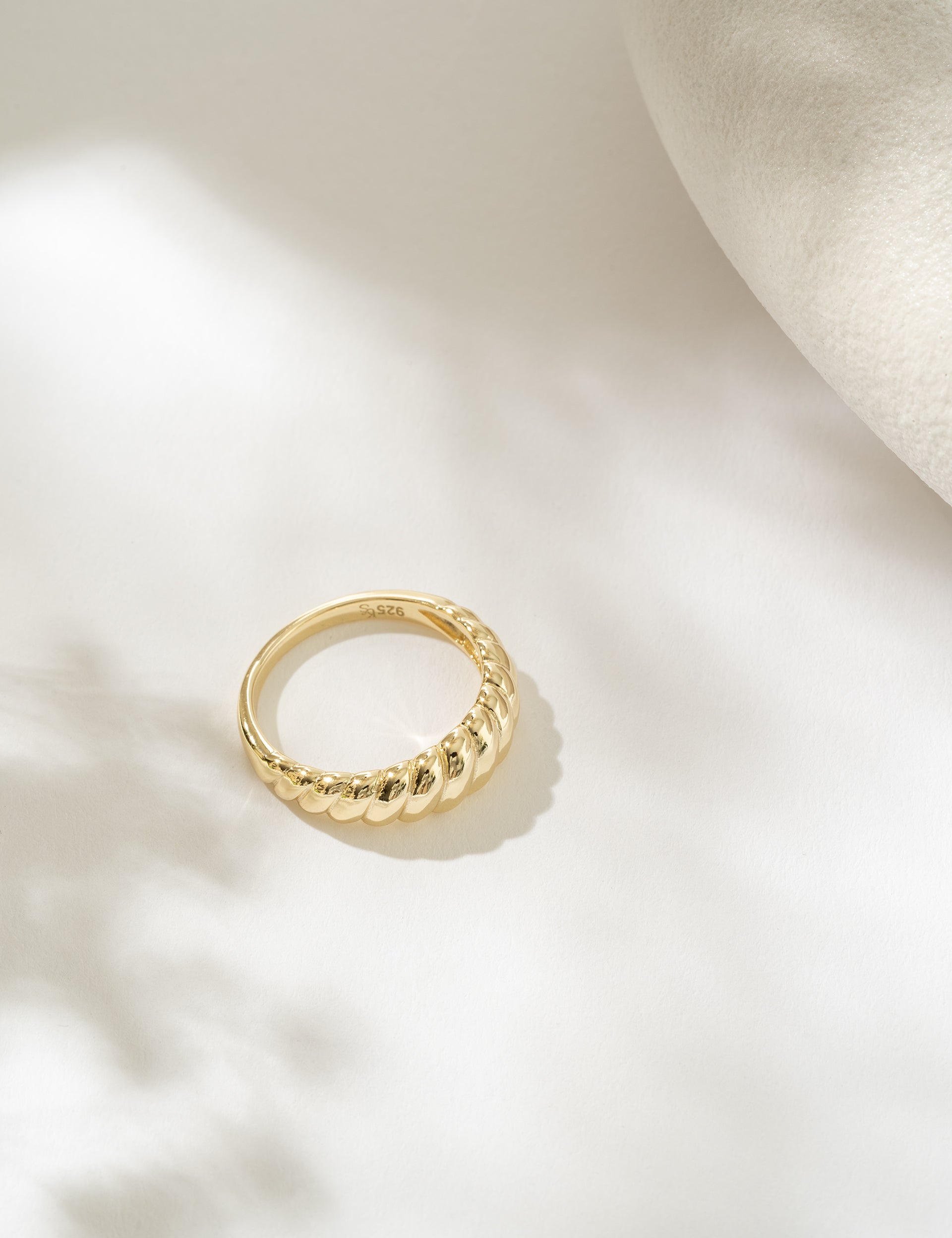 Gold ring on a light beige background