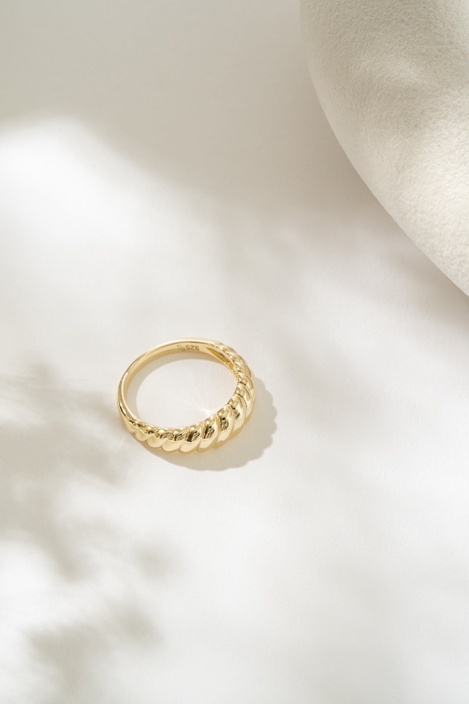 Gold ring on a light beige background