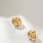 Gold hoop earrings on a light gray background