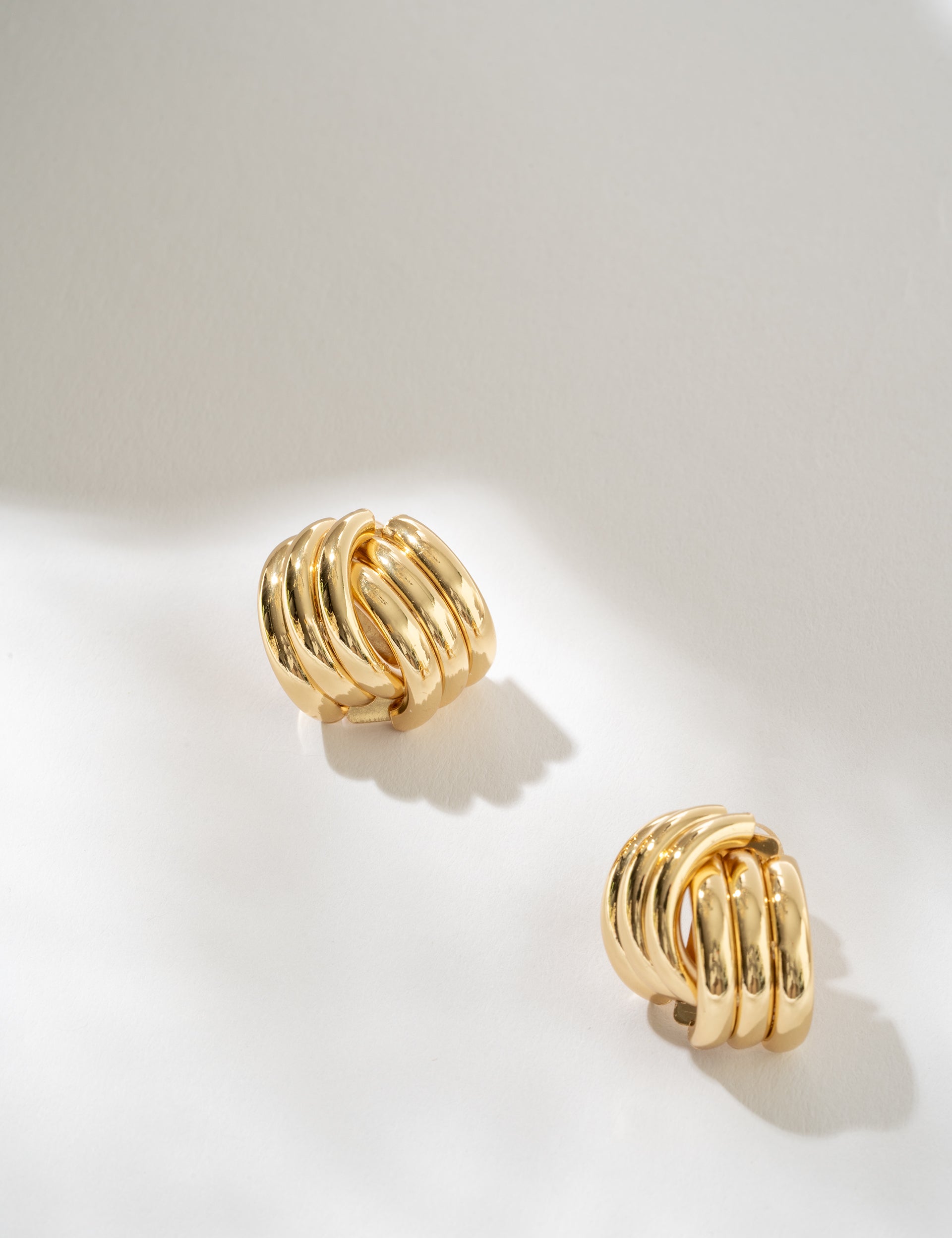 Gold hoop earrings on a light gray background