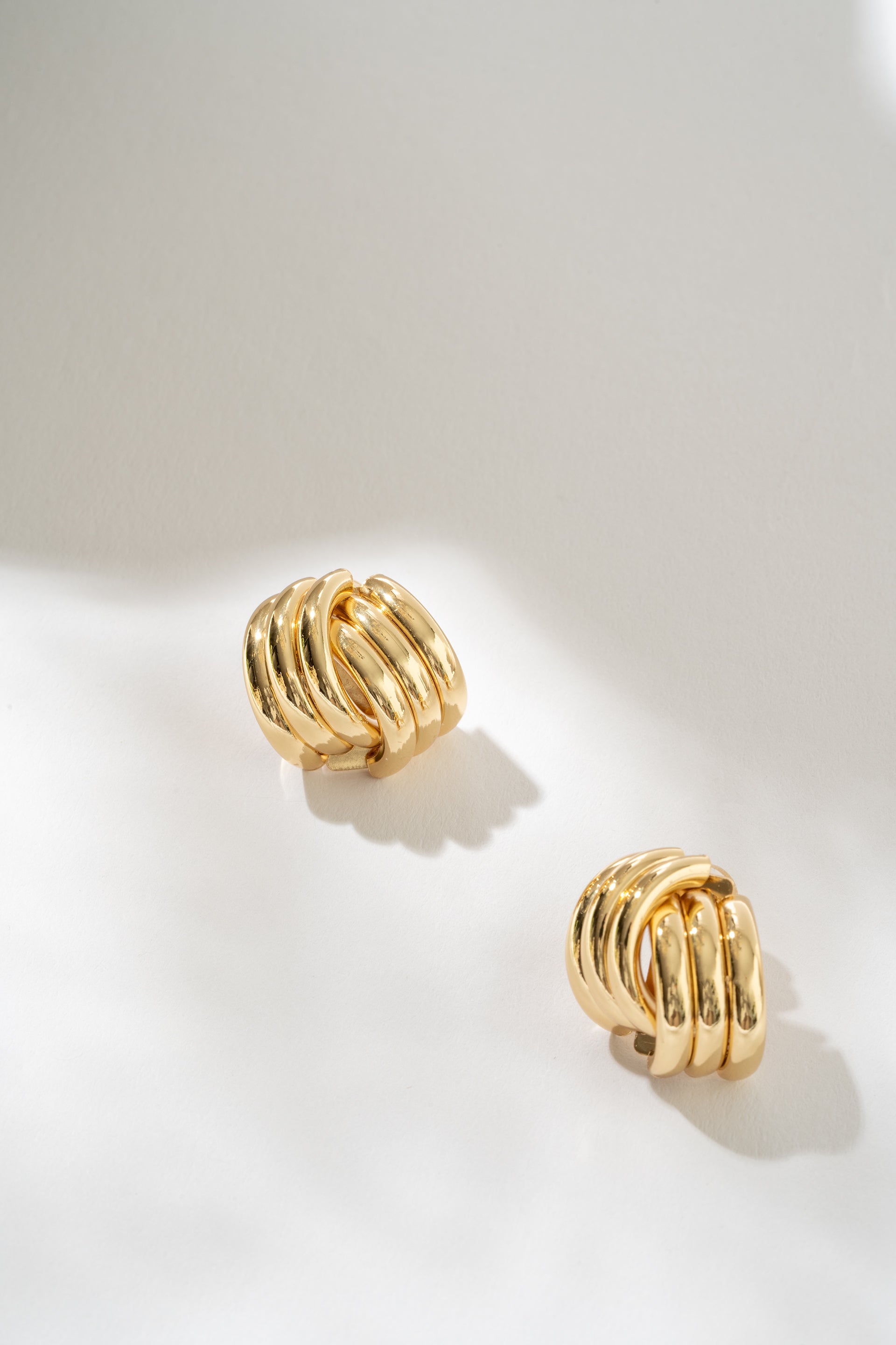Gold hoop earrings on a light gray background