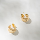 Gold hoop earrings on a light gray background