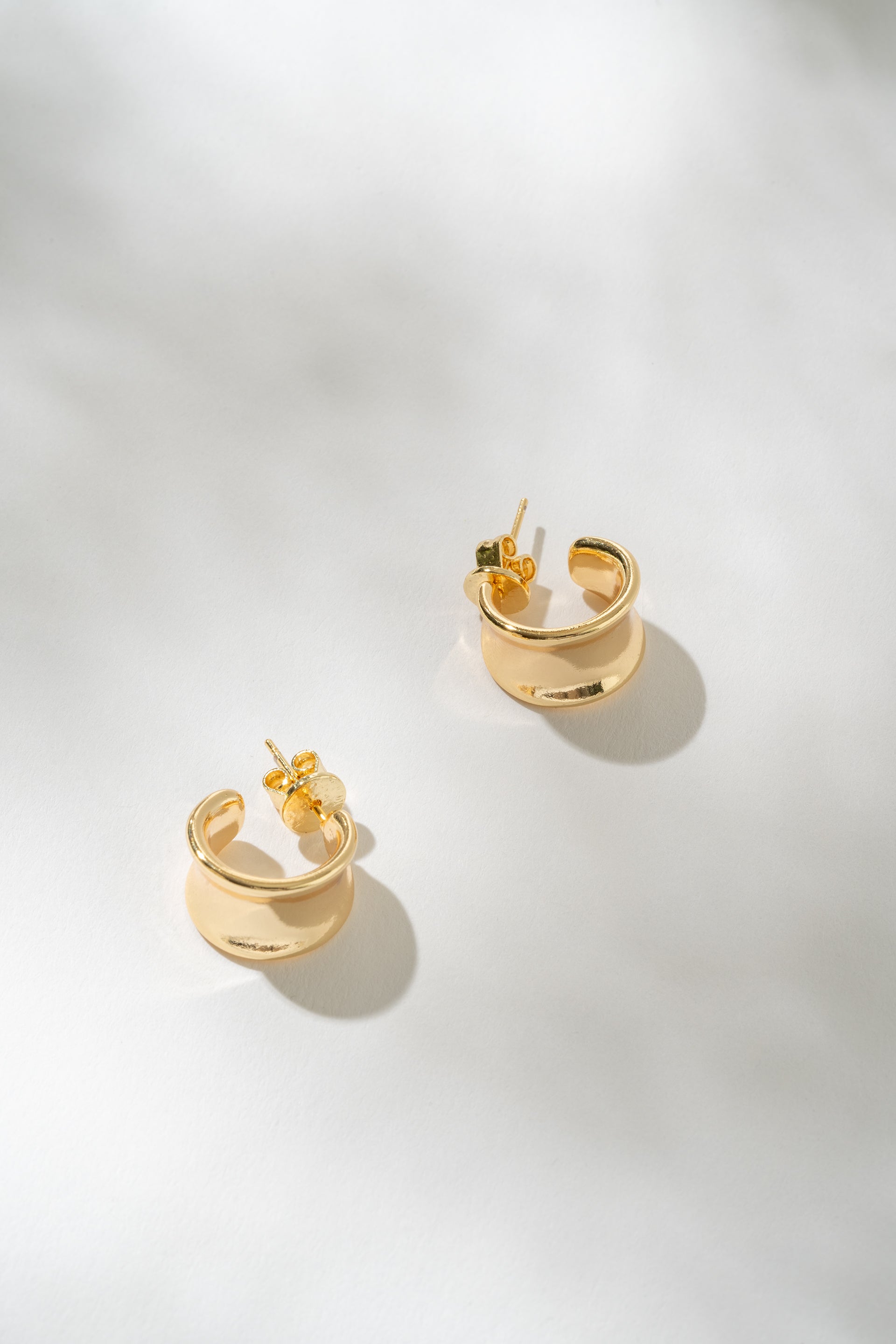 Gold hoop earrings on a light gray background