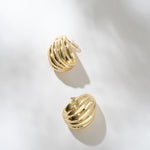 Gold hoop earrings on a light gray background