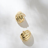 Gold hoop earrings on a light gray background