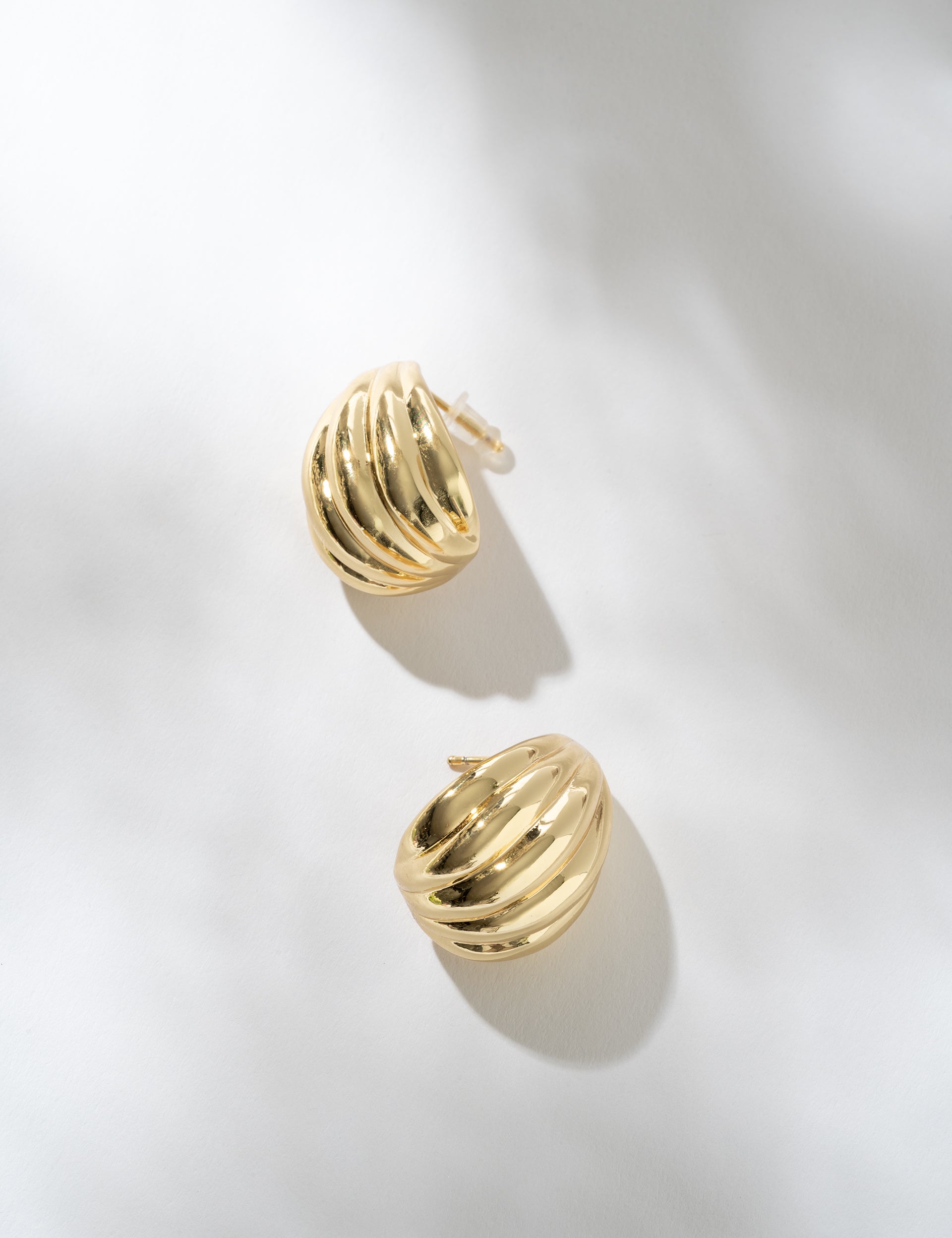 Gold hoop earrings on a light gray background