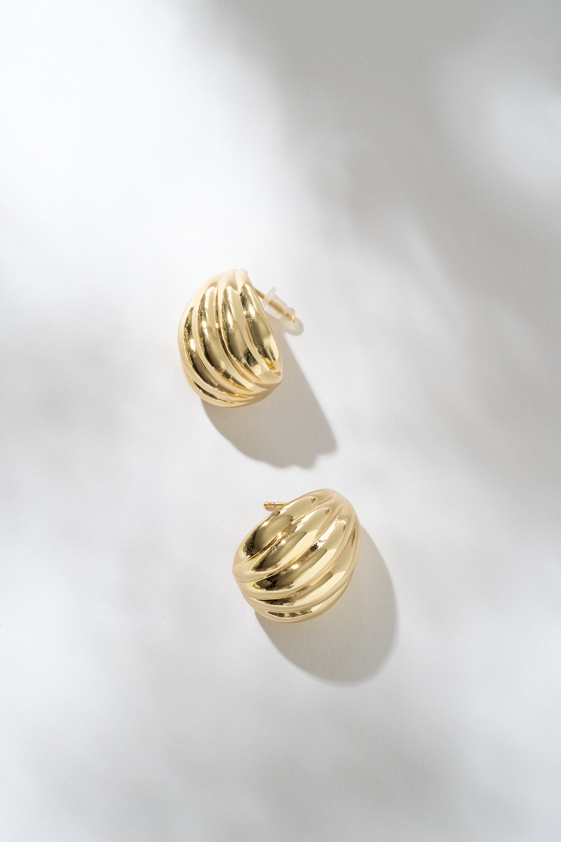 Gold hoop earrings on a light gray background