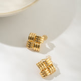 Gold basketweave earrings on a white surface