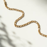 Gold chain bracelet on a light background