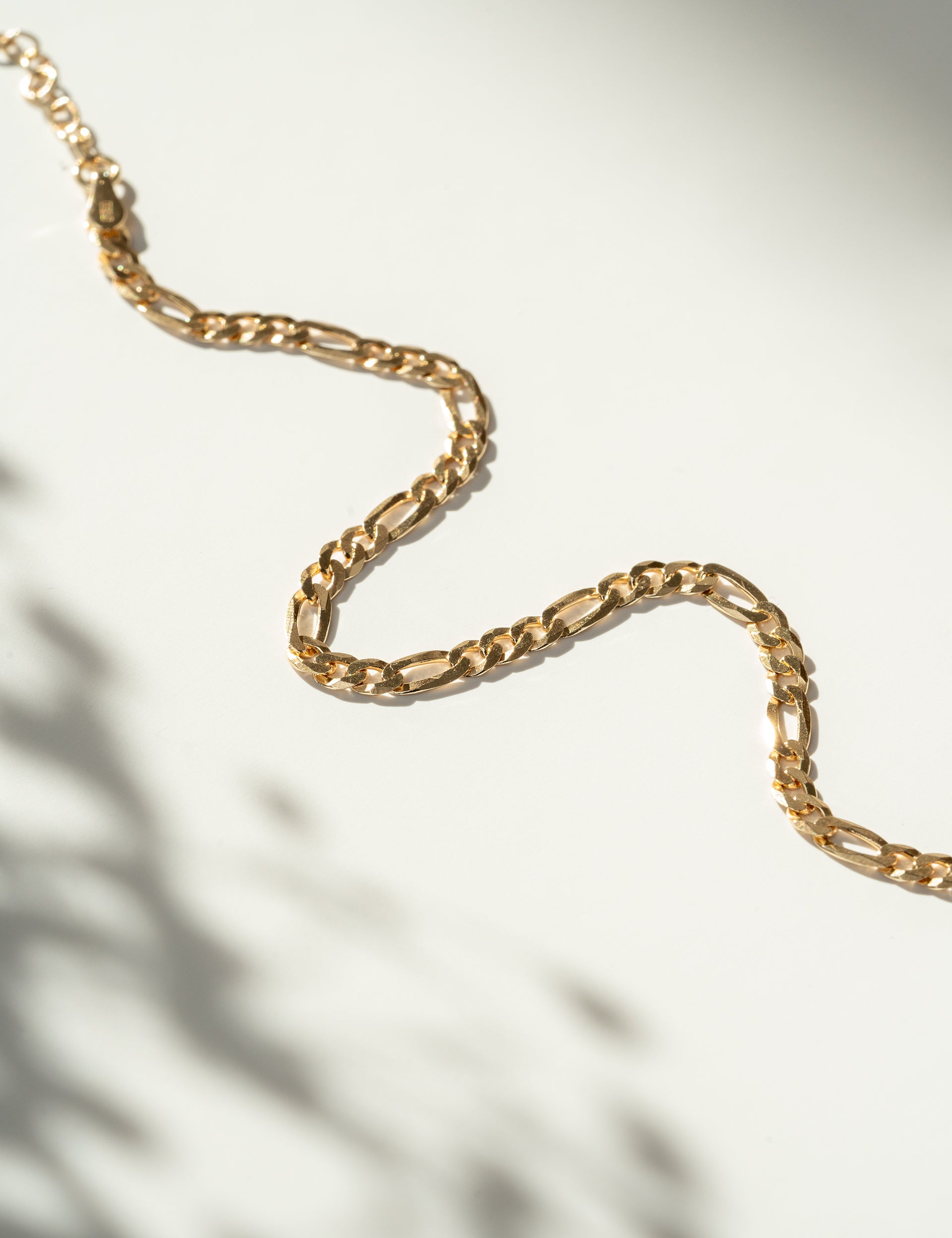 Gold chain bracelet on a light background