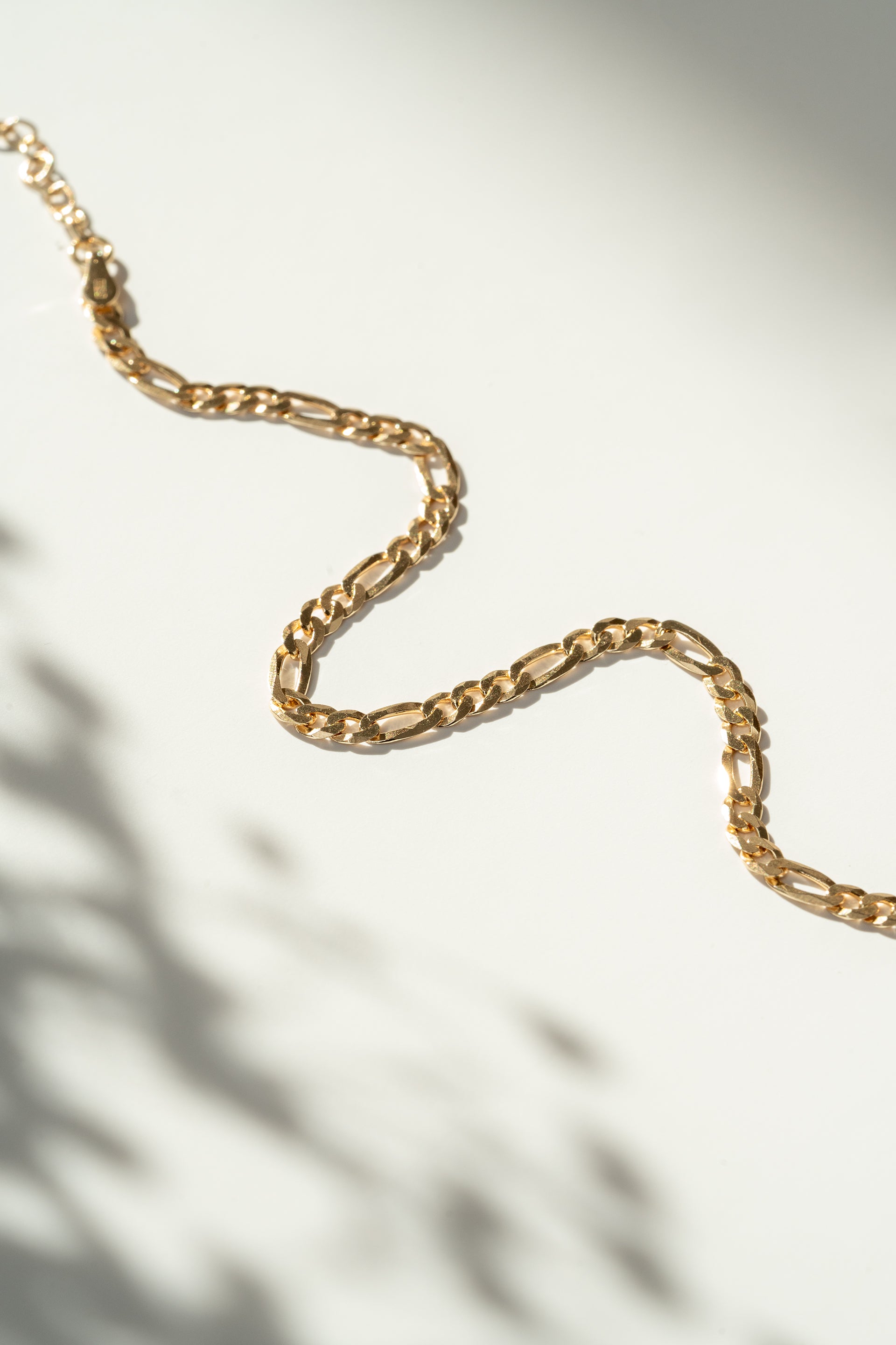 Gold chain bracelet on a light background