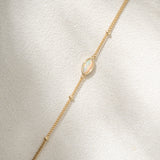 Gold bracelet with a delicate chain on a light gray background