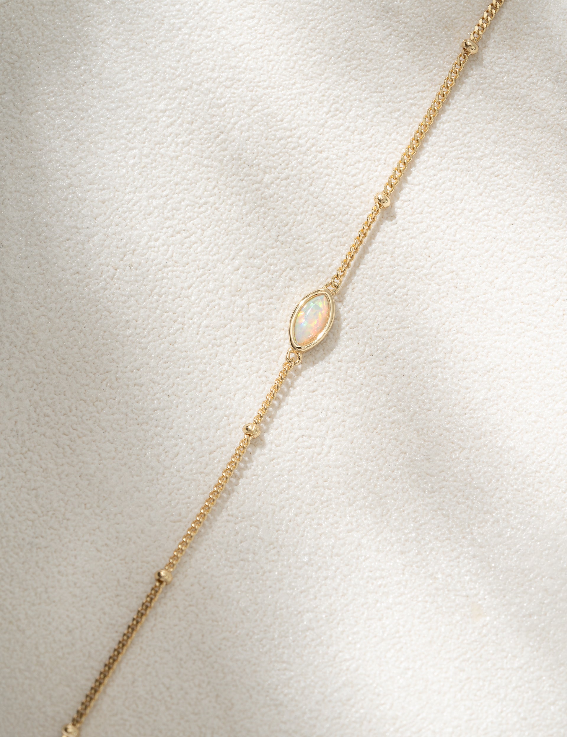 Gold bracelet with a delicate chain on a light gray background