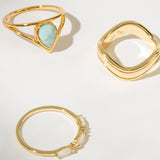 Three gold rings with different designs on a light background