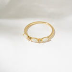 Gold ring with a central gemstone on a white background
