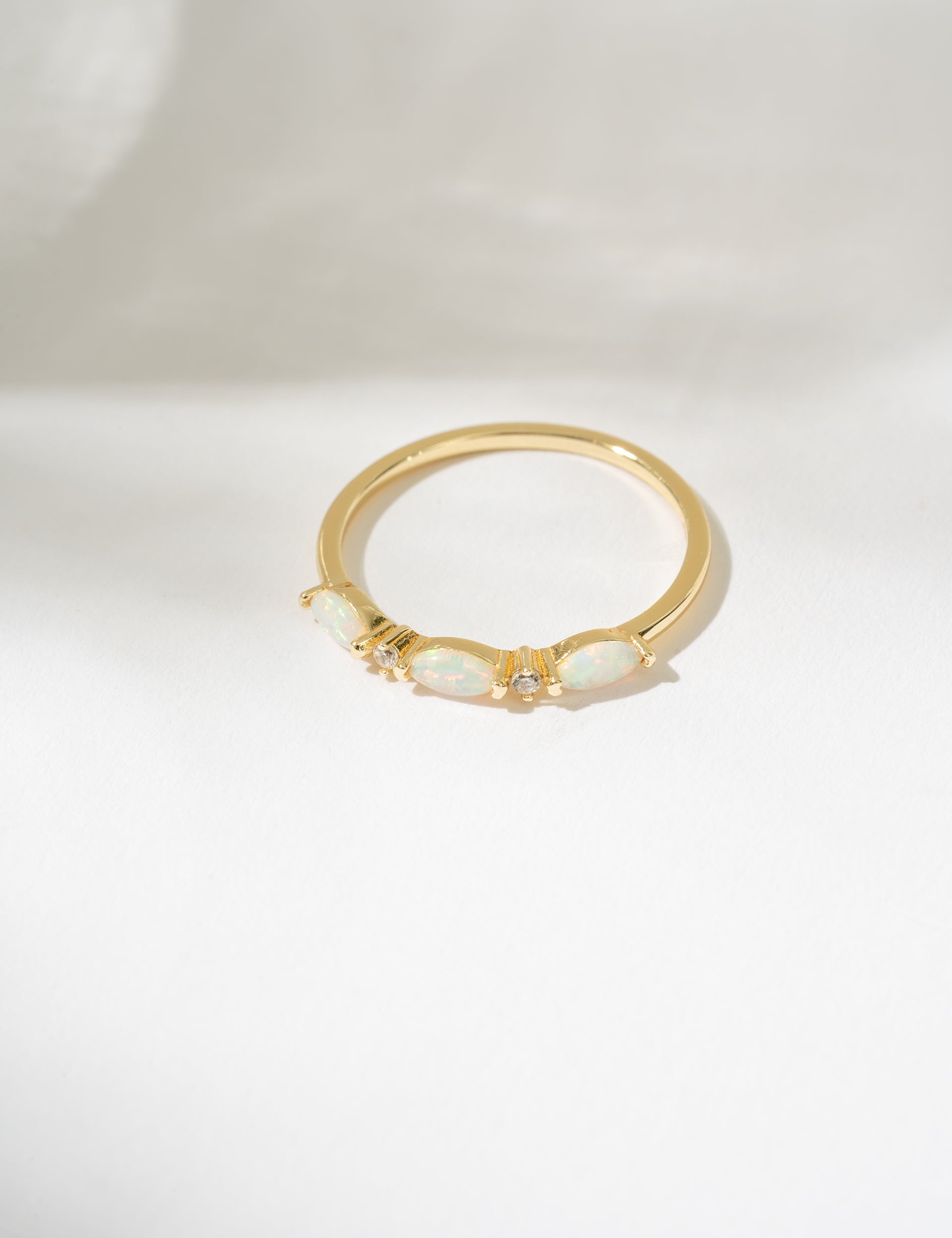 Gold ring with a central gemstone on a white background