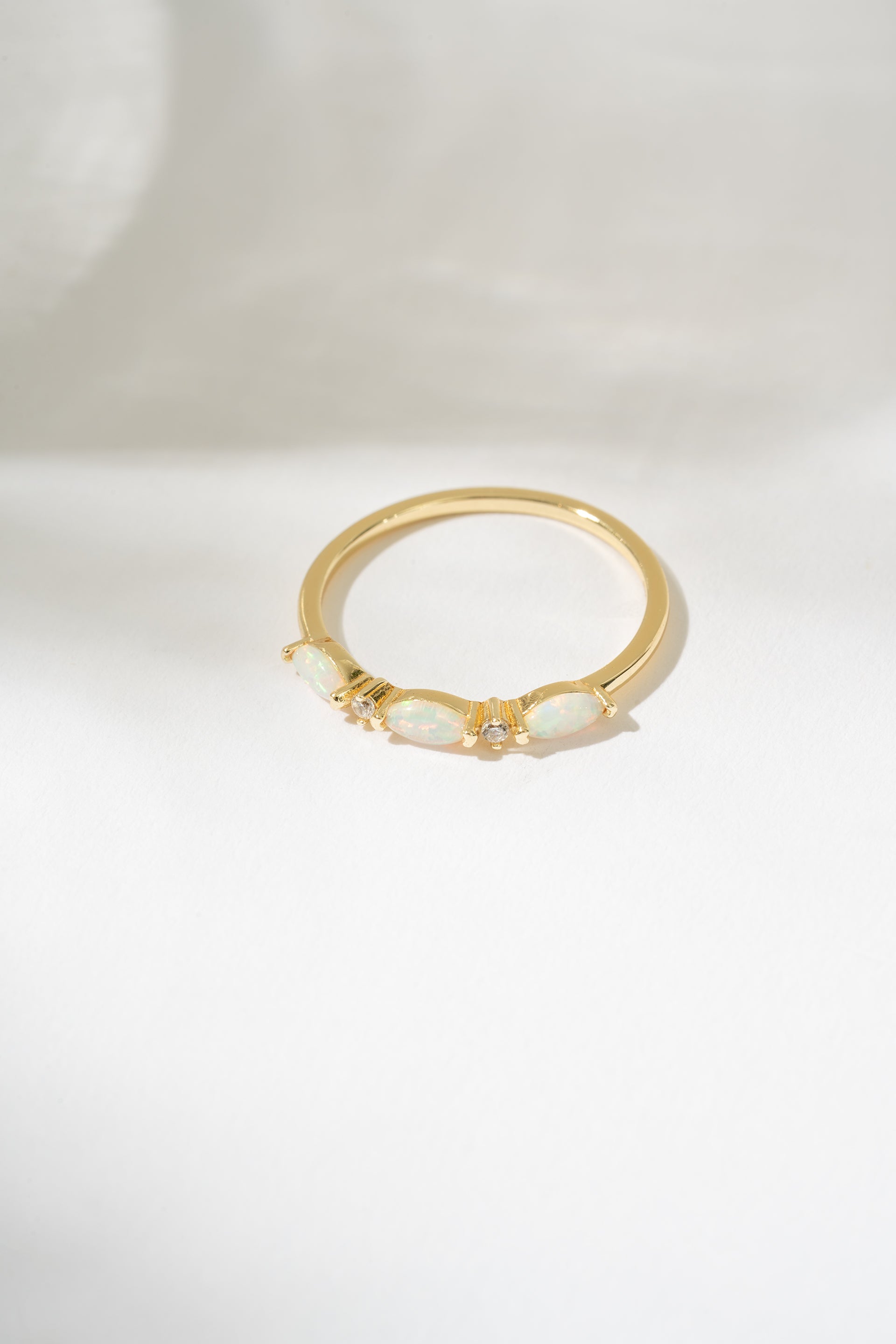 Gold ring with a central gemstone on a white background