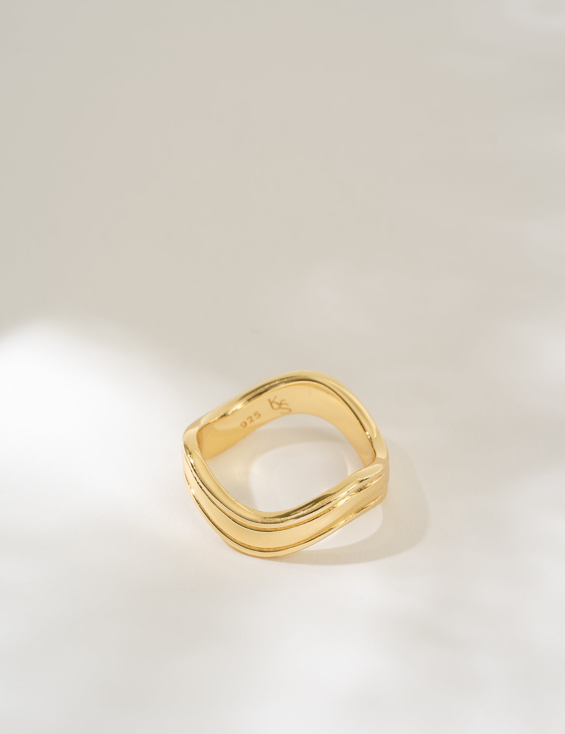 Gold ring on a light gray background