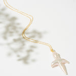 Gold necklace with a pearl cross pendant