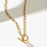 Gold necklace with a pearl pendant on a white background