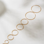 Set of gold hoop earrings on a light background