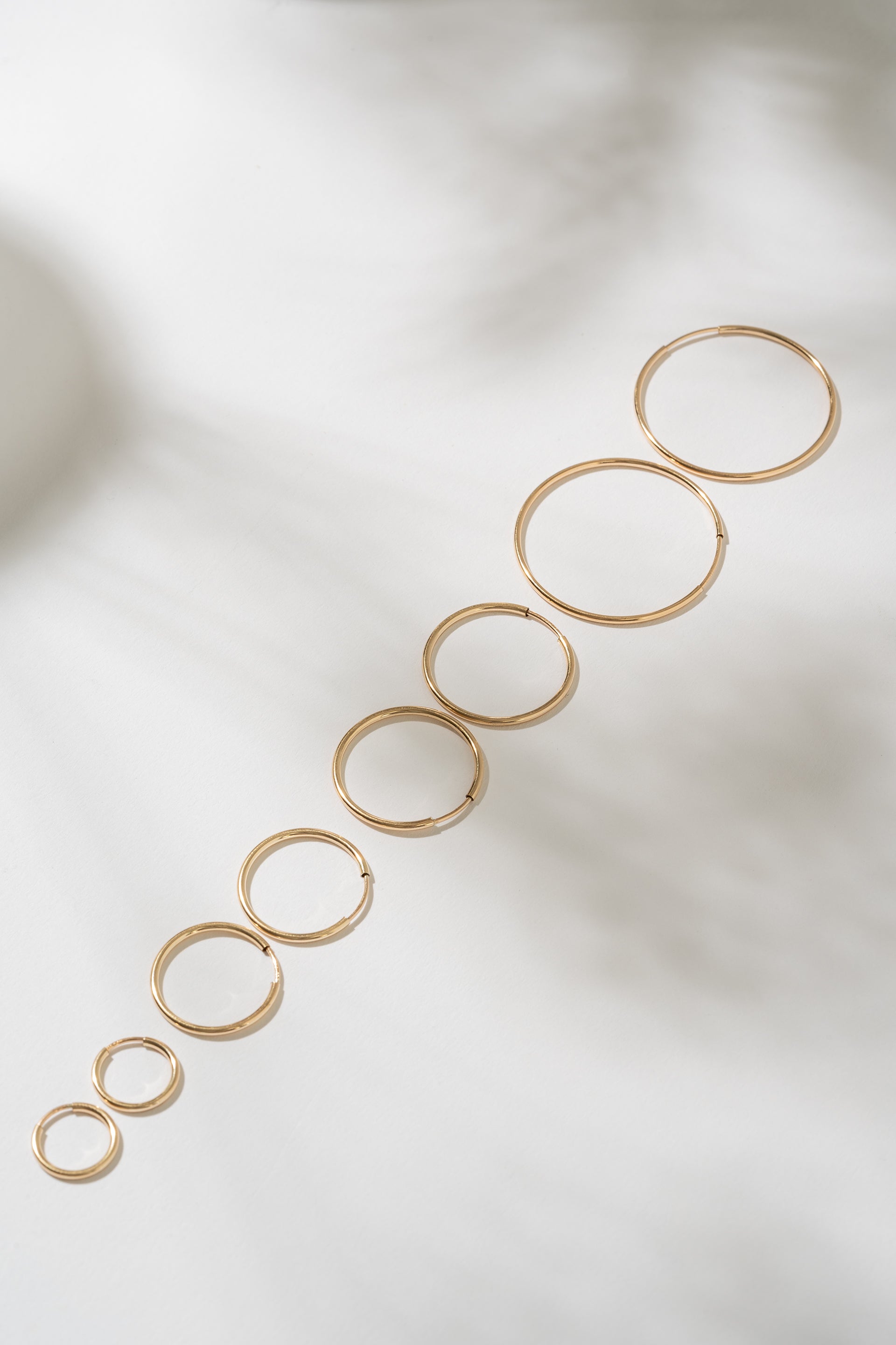 Set of gold hoop earrings on a light background