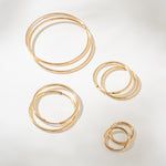 Set of gold hoop earrings on a light gray background