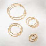 Set of gold hoop earrings on a light gray background