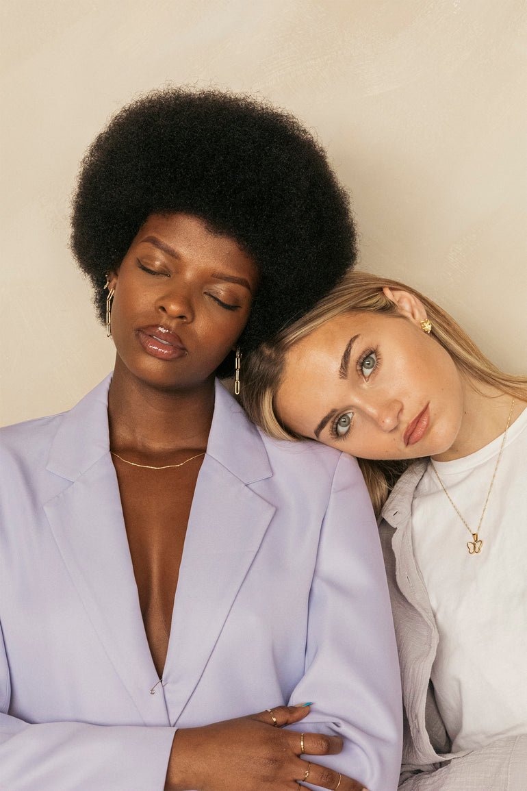 two woman resting head with gold jewelry