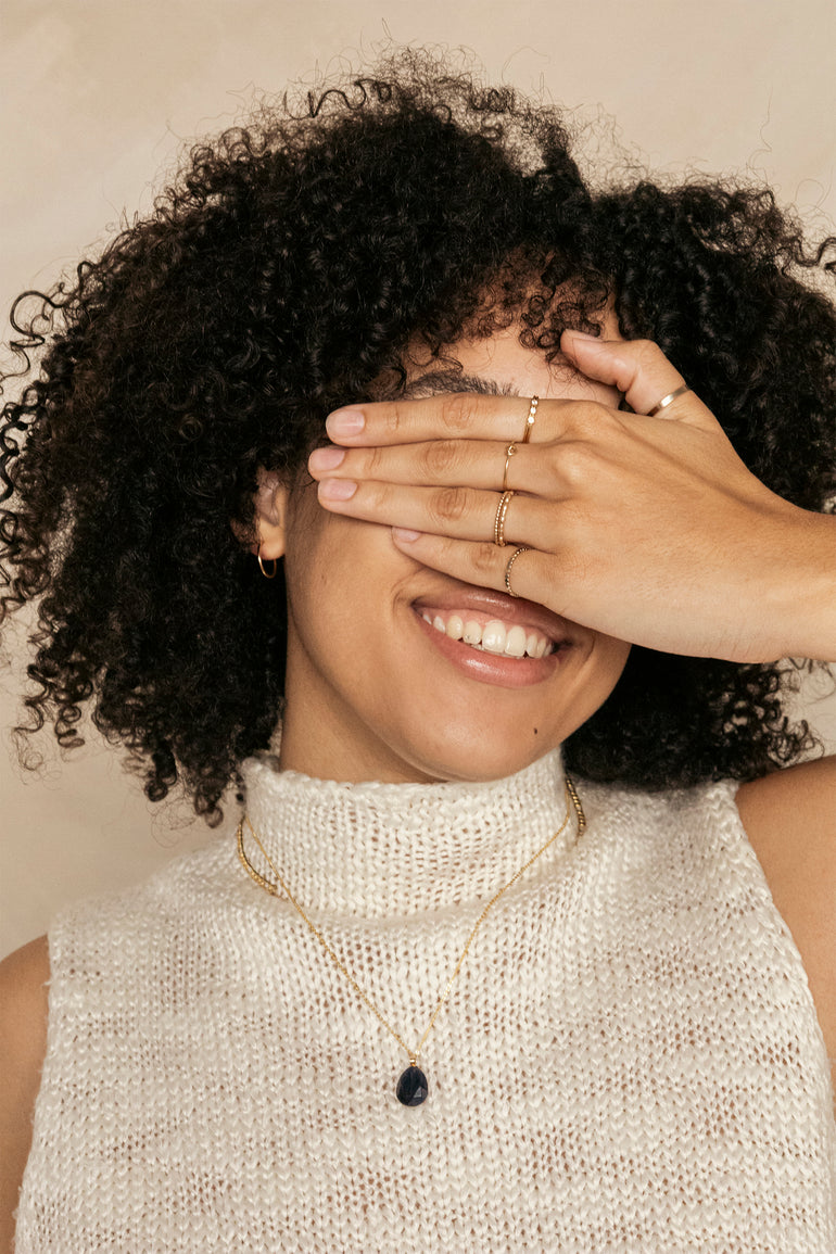 woman smiling with gold filled jewelry