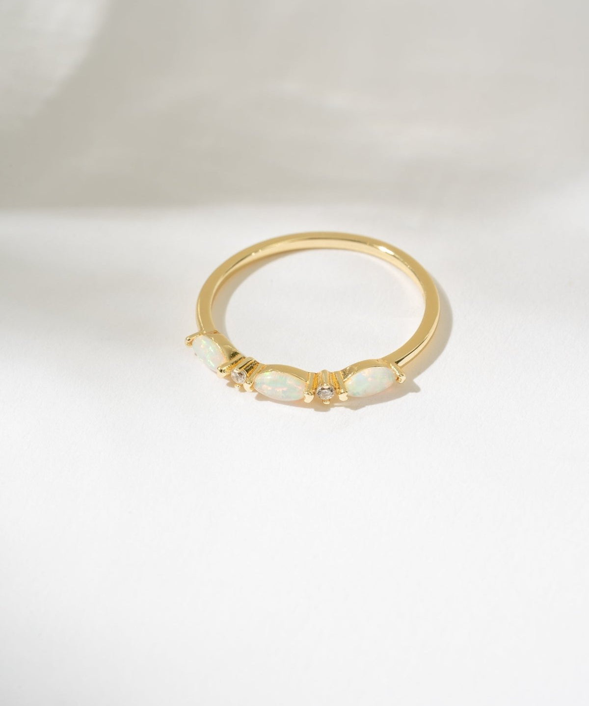 Gold ring with a central gemstone on a white background