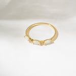 Gold ring with a central gemstone on a white background