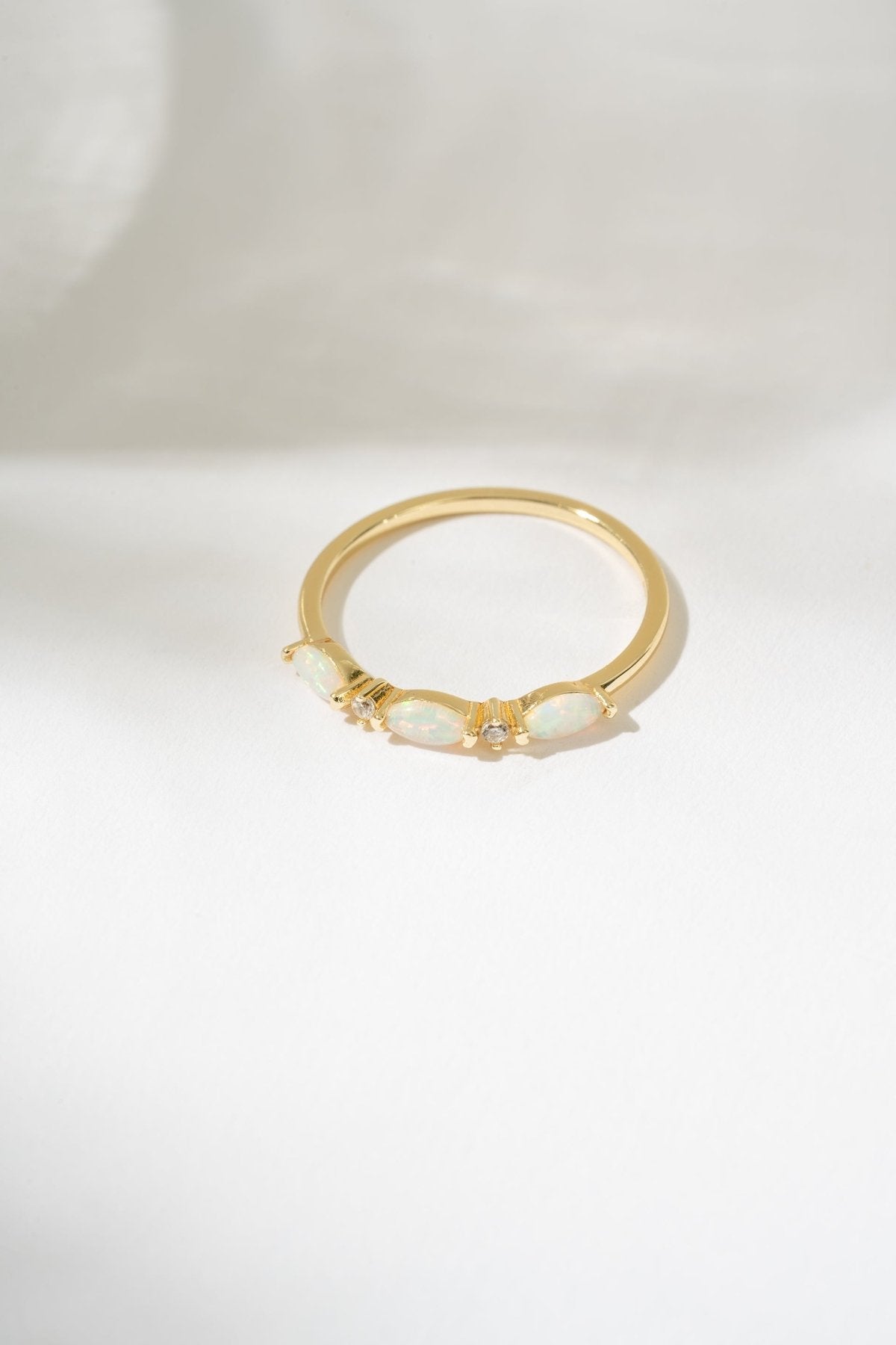 Gold ring with a central gemstone on a white background