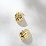 Gold hoop earrings on a light gray background