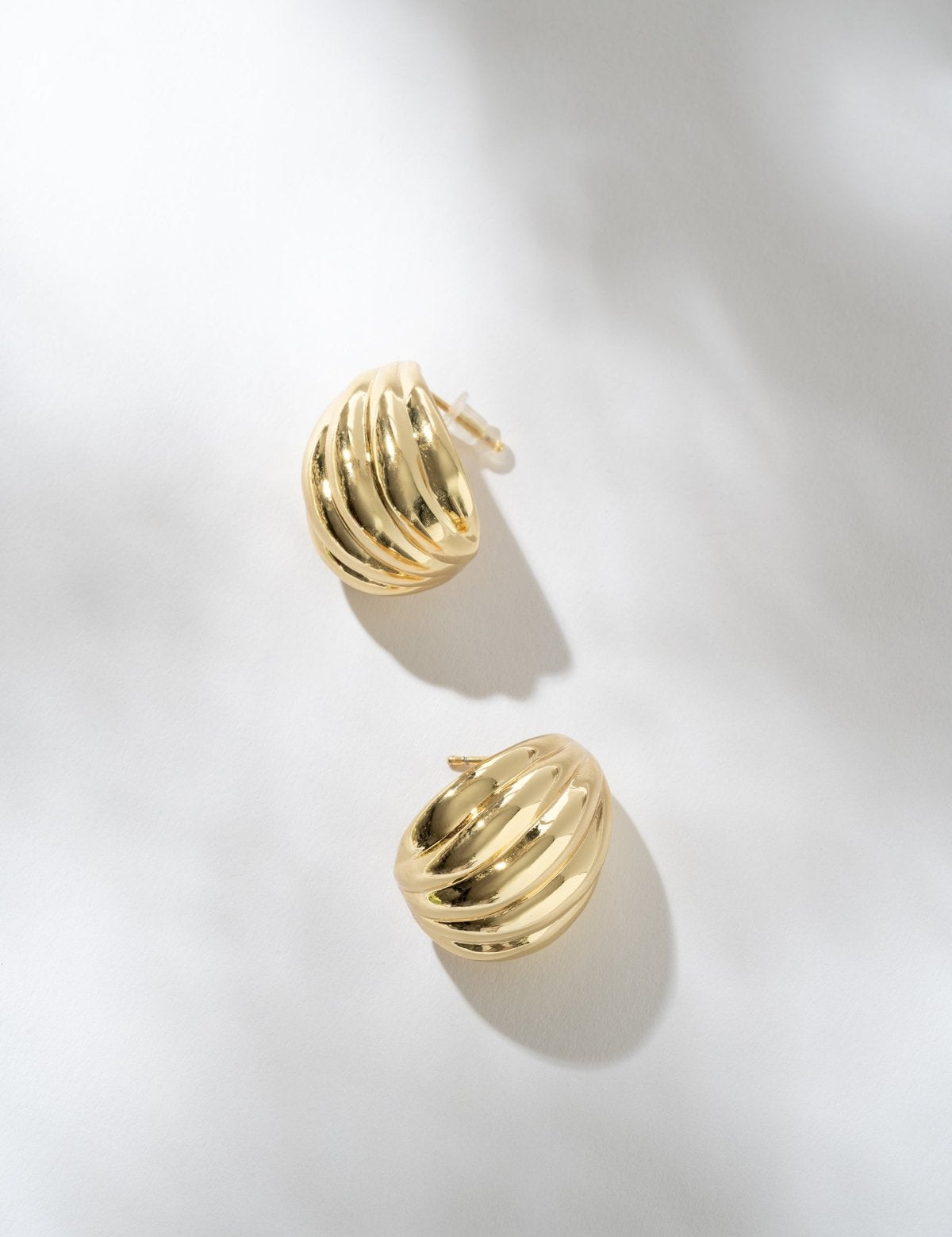 Gold hoop earrings on a light gray background