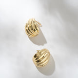 Gold hoop earrings on a light gray background