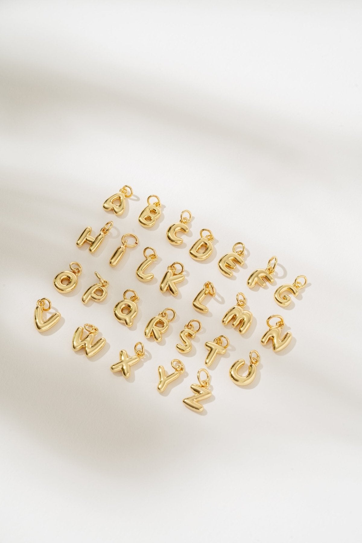 Gold letter charms on a white background